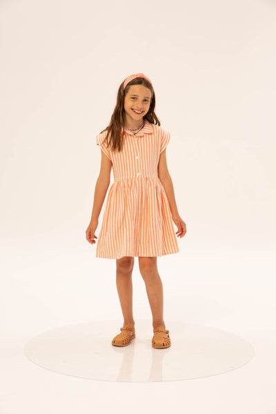 Fatima Dress Coral Stripe van Wander & Wonder met een gestreepte print in koraalroze en wit, knoopsluiting en een aansluitende taille. | Verkrijgbaar bij Little Fashion Addict