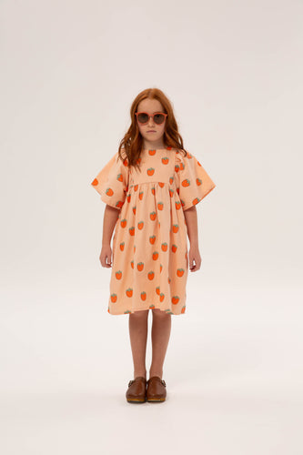 Benedita Dress Persimmon van Wander & Wonder met een perzikkleurige achtergrond en aardbeienprint. | Verkrijgbaar bij Little Fashion Addict