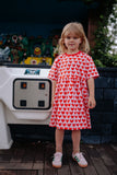 Meisje draagt lichtroze Daily Brat jurk met hartjesprint | Ontdek Daily Brat bij Little Fashion Addict