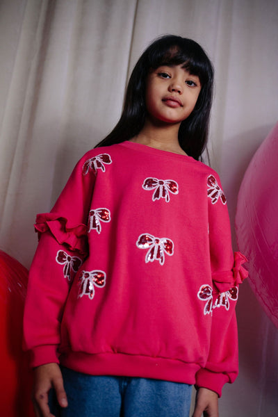 Donkerroze meisjessweater met glinsterende strikjes van Daily Brat – City Notes Collectie | Ontdek Daily Brat bij Little Fashion Addict