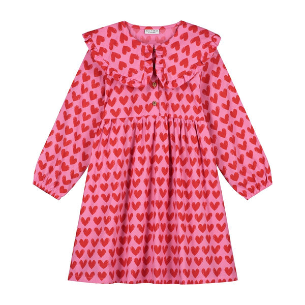 Roze Adore jurk met rode hartjesprint van Daily Brat, met rucheskraag en lange mouwen – gemaakt van biologisch katoen.