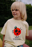 Daily Brat unisex T-shirt in zachtgeel met lieveheersbeestje print vooraan | What Ever T-shirt Pale Banana - Verkrijgbaar bij Little Fashion Addict