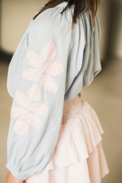 Lichtblauwe meisjesblouse van Jenest met roze bloemenborduursel op de mouwen | Coco Blouse Grape Blue | verkrijgbaar bij Little Fashion Addict