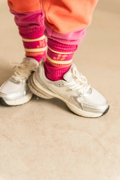 Fuchsia roze sportsokken van Jenest met kleurrijke strepen en logo, ideaal voor actieve kinderen | Verkrijgbaar bij Little Fashion Addict