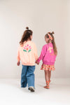 Pippa Sweater Peach Orange van Jenest – abrikooskleurige oversized meisjes sweater met bloemenprint op de rug | Ontdek Jenest bij Little Fashion Addict