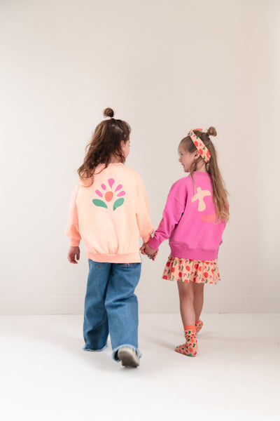 Pippa Sweater Peach Orange van Jenest – abrikooskleurige oversized meisjes sweater met bloemenprint op de rug | Ontdek Jenest bij Little Fashion Addict