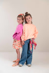 Pippa Sweater Peach Orange van Jenest – abrikooskleurige oversized meisjes sweater met bloemenprint op de rug | Ontdek Jenest bij Little Fashion Addict