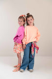 Pippa Sweater Peach Orange van Jenest – abrikooskleurige oversized meisjes sweater met bloemenprint op de rug | Ontdek Jenest bij Little Fashion Addict