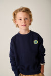 Donkerblauwe Jongenssweater met kleine patch vooraan en op de achterkant een grote skateboardprint van Tumble 'n Dry | Heelflip Sweater Navy Blazer