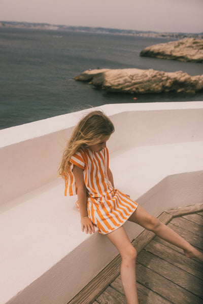 We Are Kids Top Jodie Oranje Strepen – Vrolijk topje voor meisjes in oranje en witte strepen, gemaakt van biologisch katoen | Verkrijgbaar bij Little Fashion Addict
